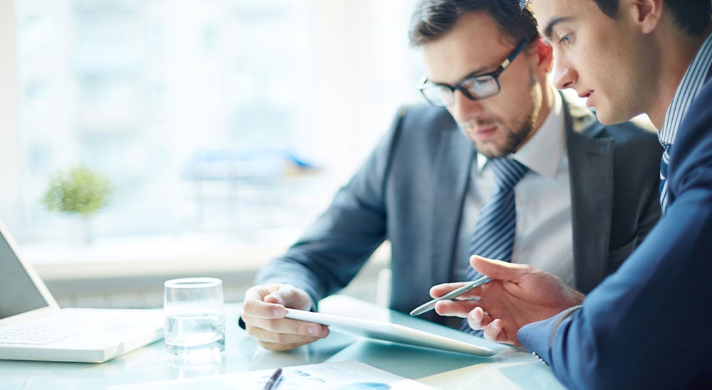 2 men looking at tablet