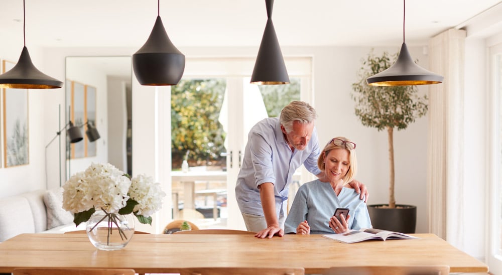 Couple at dining table looking at phone