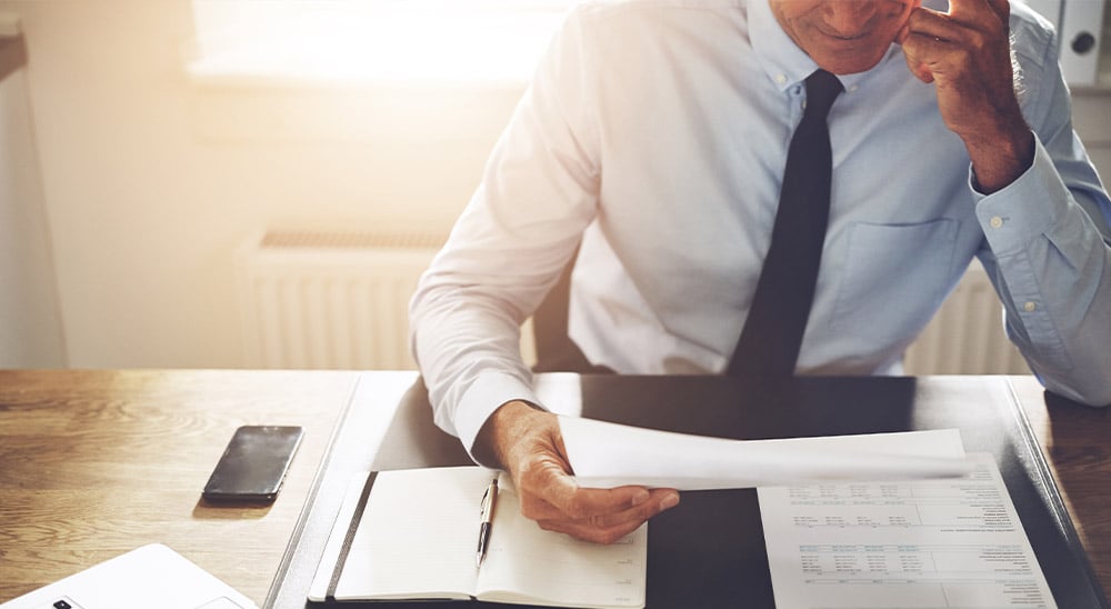 Man reading document on desk