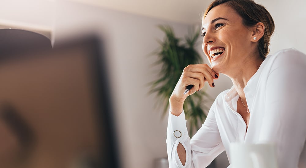 A female lender smiling while sitting at her desk