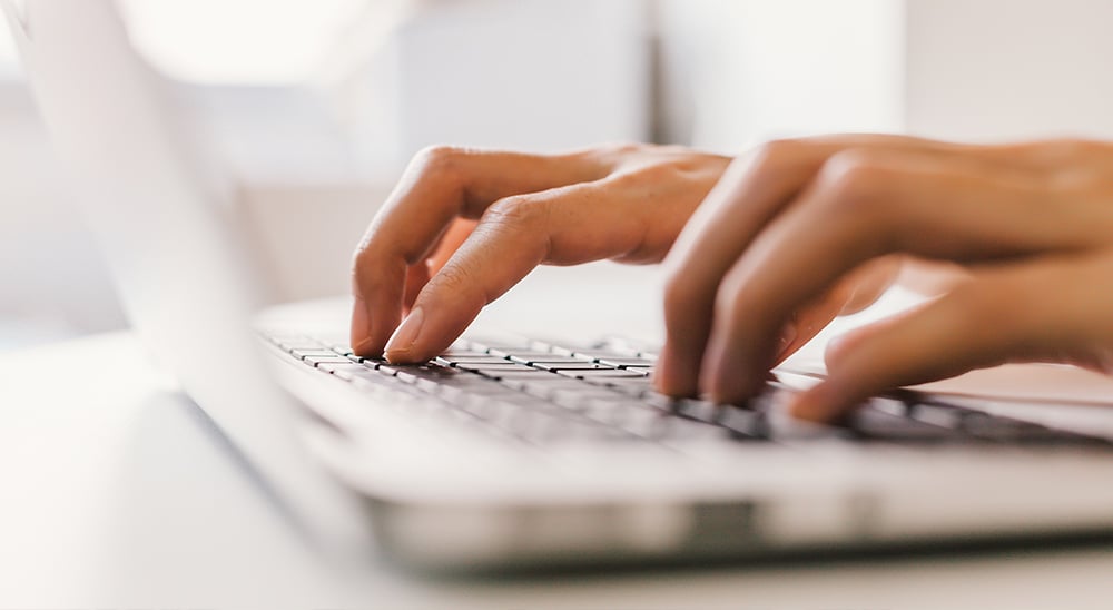 Fingers typing on a laptop keyboard