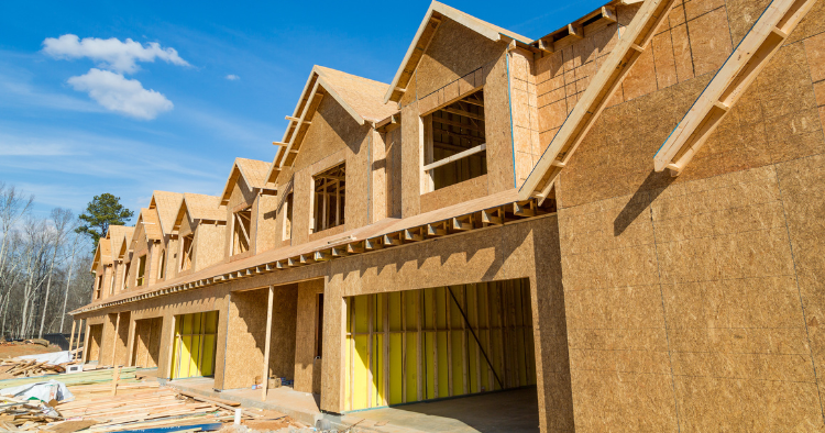 a row of homes under construction, at the framing stage