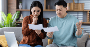 un couple regarde les informations reçues par la poste