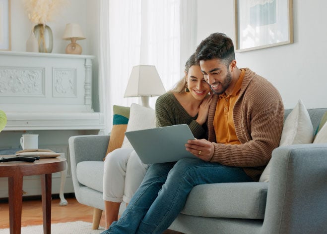 Couple happily looking at laptop screen.