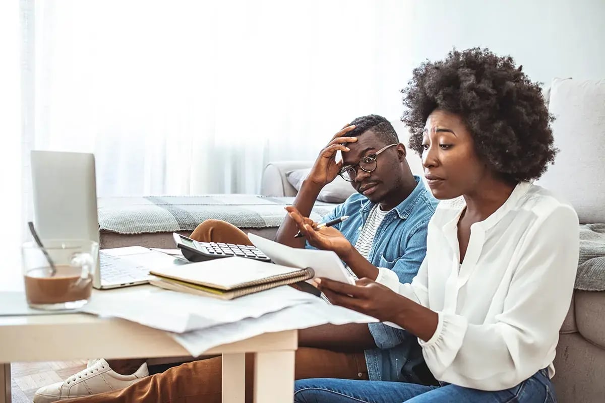 Frustrated couple looking at document