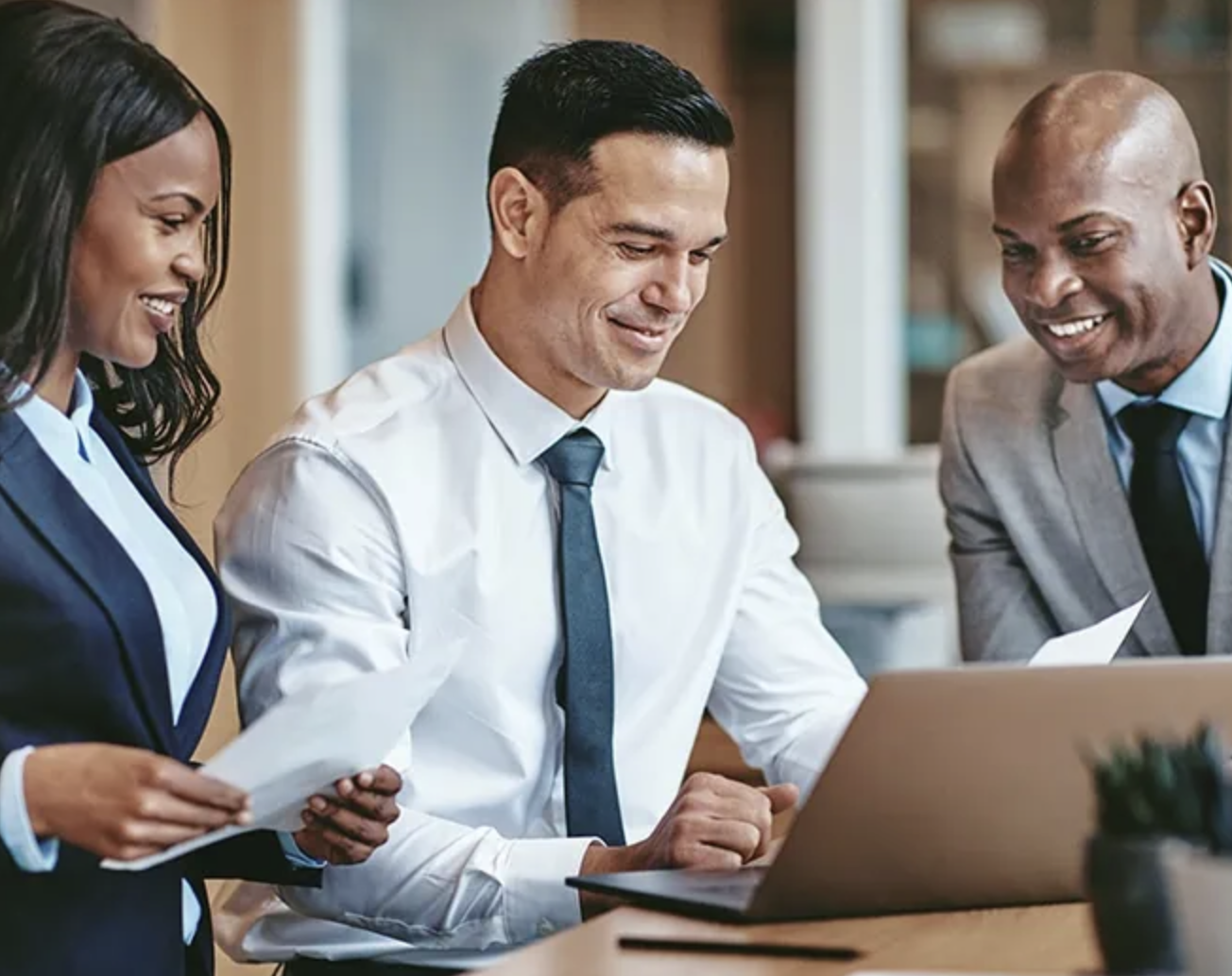 three people looking into laptop