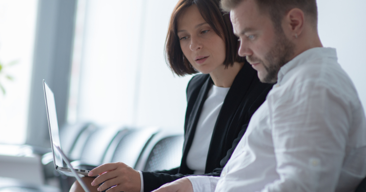 two legal professionals consider concerning information on their laptop screens